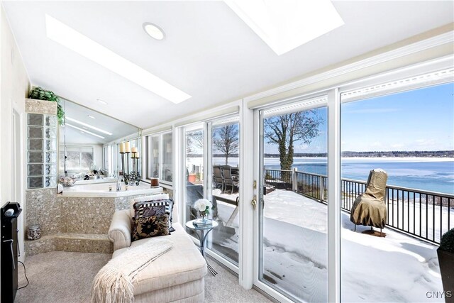 sunroom with vaulted ceiling with skylight and a water view