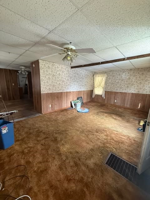 100 Cruger St, Bath, NY 14810 - carpeted spare room featuring a paneled ceiling, a ceiling fan, and wainscoting