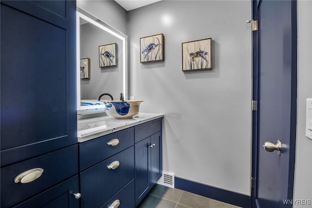 bathroom with baseboards, vanity, visible vents, and tile patterned floors