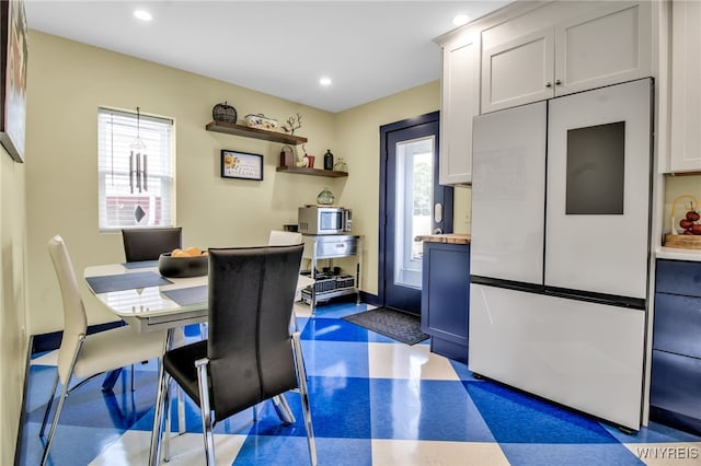 dining space featuring dark floors, baseboards, and recessed lighting