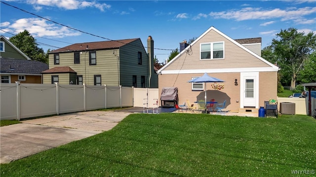 back of house featuring a yard, a patio area, a fenced backyard, and central air condition unit