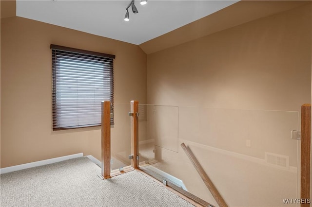 bathroom featuring rail lighting, visible vents, vaulted ceiling, and baseboards