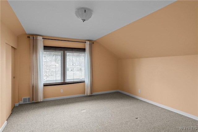 bonus room featuring lofted ceiling, carpet flooring, visible vents, and baseboards