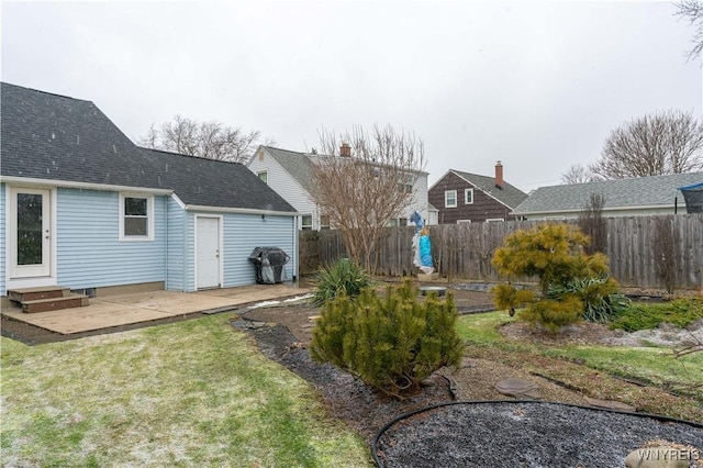 view of yard with entry steps, a patio area, and fence