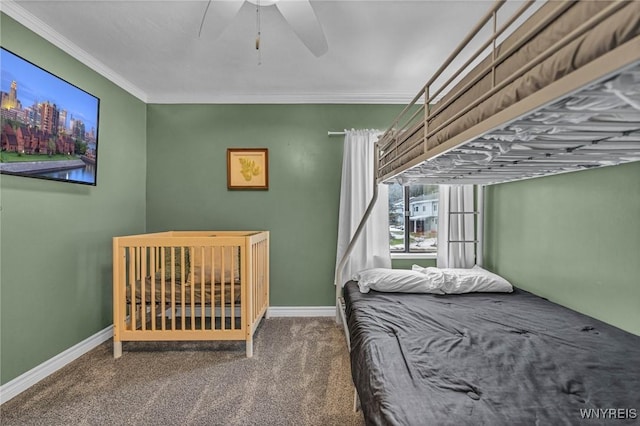 carpeted bedroom featuring ornamental molding, baseboards, and a ceiling fan