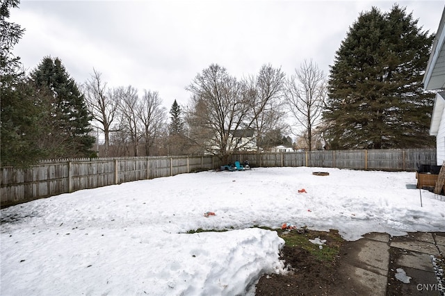 yard layered in snow featuring a fenced backyard