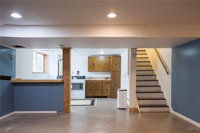 interior space featuring baseboards, washer / clothes dryer, brown cabinets, concrete floors, and recessed lighting