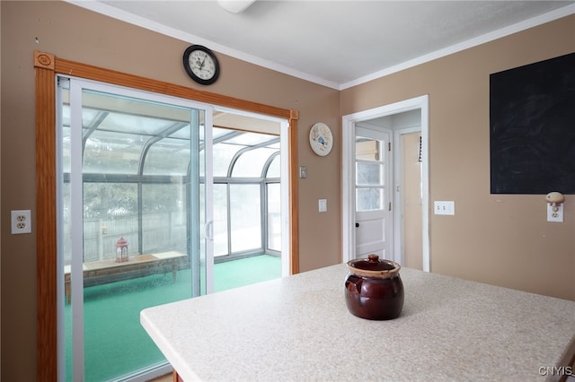 kitchen with light countertops, a sunroom, and crown molding