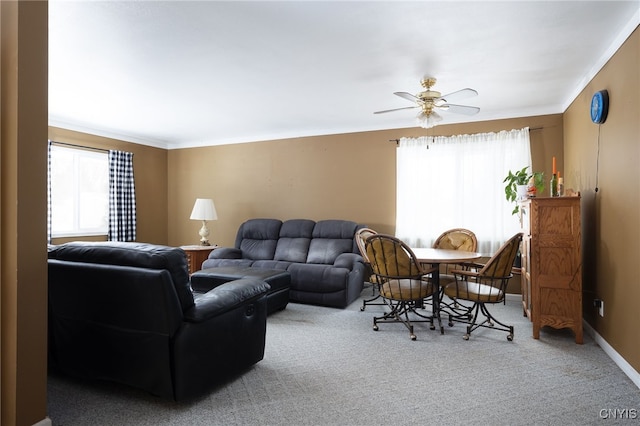 living area featuring carpet, plenty of natural light, baseboards, and crown molding