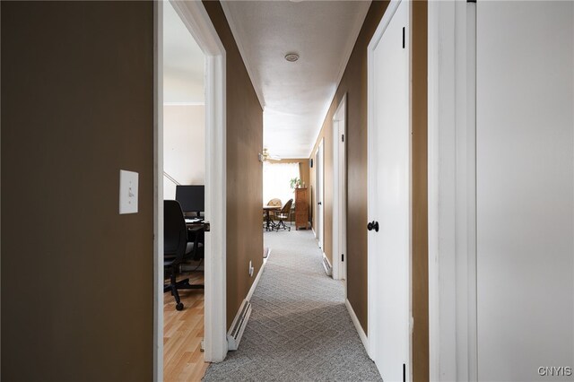 corridor featuring light colored carpet and baseboards