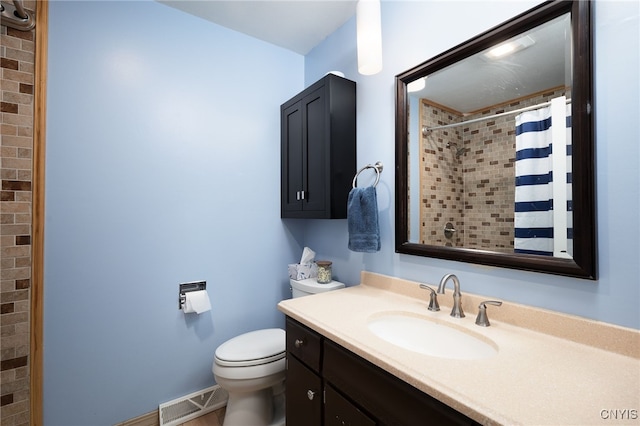 bathroom featuring visible vents, toilet, a tile shower, vanity, and baseboards