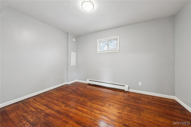 empty room with hardwood / wood-style floors, a baseboard radiator, and baseboards