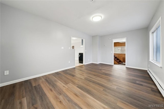 unfurnished living room with a baseboard radiator, baseboards, and wood finished floors