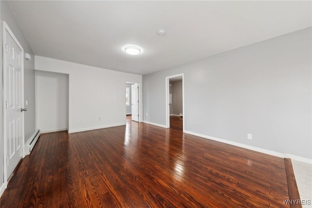 unfurnished room featuring baseboards, a baseboard heating unit, and wood finished floors