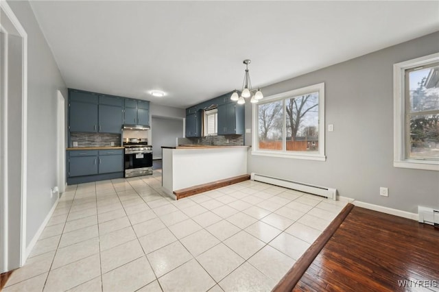 kitchen with a baseboard heating unit, stainless steel stove, decorative backsplash, and an inviting chandelier