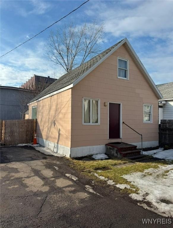 back of house with entry steps and fence