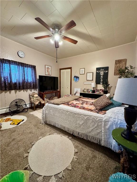 carpeted bedroom with a baseboard radiator and a ceiling fan