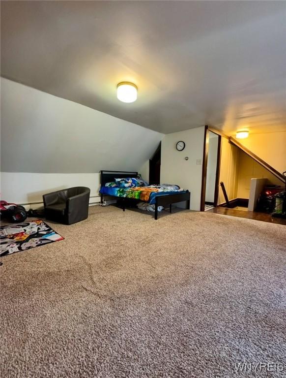 bedroom featuring carpet and vaulted ceiling