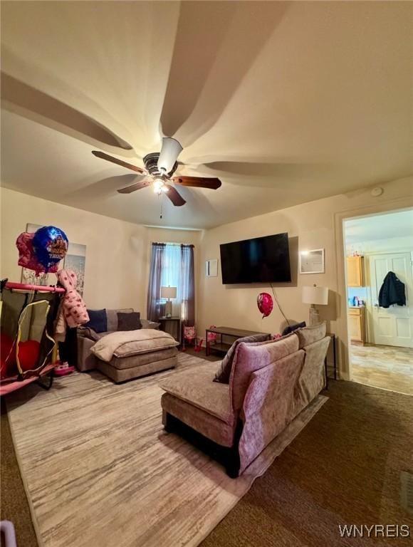 living area featuring a ceiling fan and carpet flooring