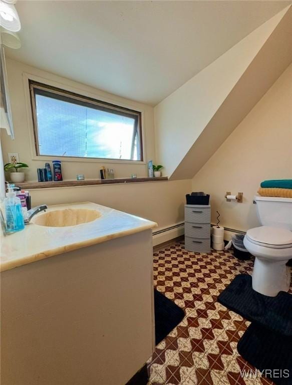 bathroom with lofted ceiling, toilet, baseboard heating, vanity, and tile patterned floors