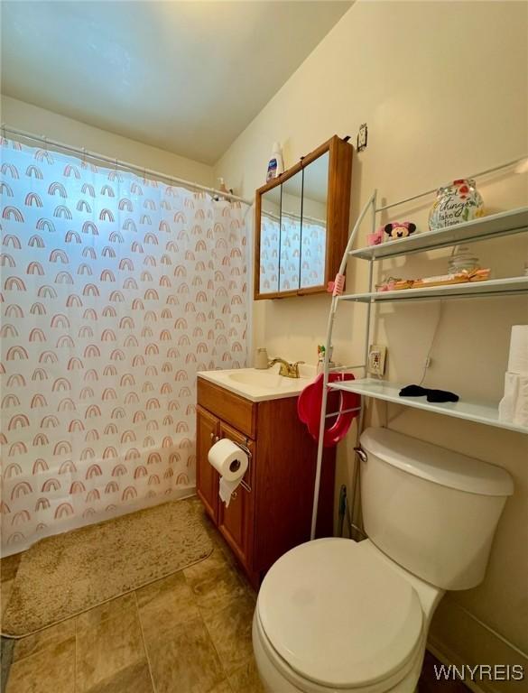 full bath featuring toilet, curtained shower, and vanity