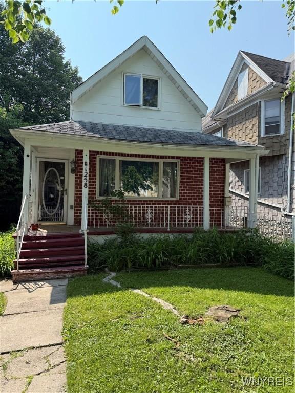 1258 W Ave, Buffalo, NY 14213 - view of front of home with a shingled roof, brick siding, and a front yard