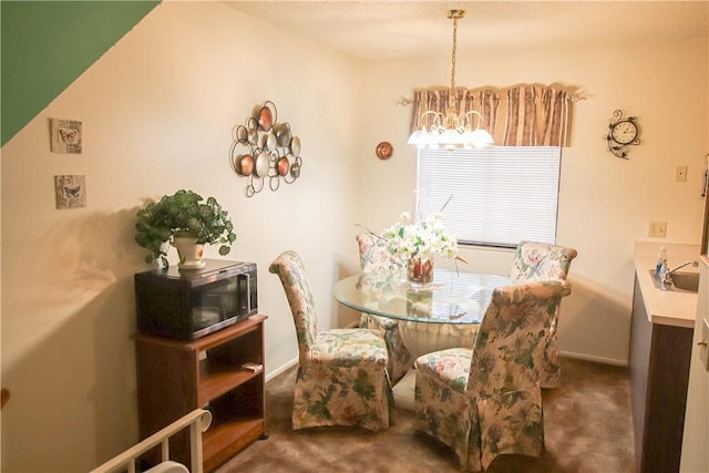 dining area with an inviting chandelier, baseboards, and carpet flooring