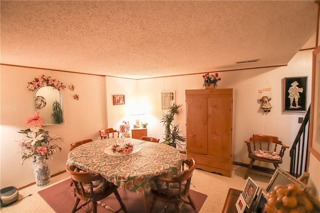 dining area with a textured ceiling, baseboards, and tile patterned floors