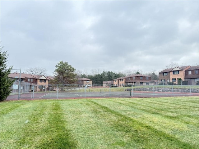 exterior space featuring a tennis court and fence