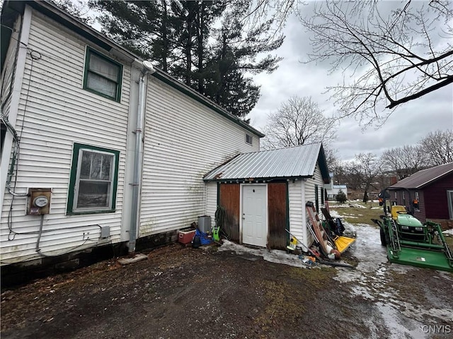 rear view of property with an outbuilding and metal roof