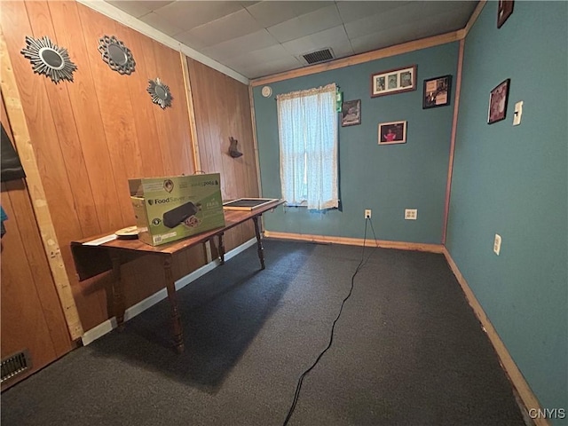 office with visible vents, wooden walls, and baseboards