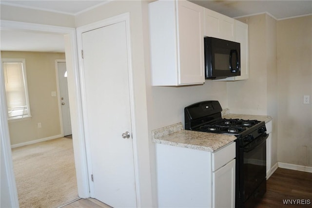 kitchen featuring black appliances, light countertops, white cabinetry, and baseboards