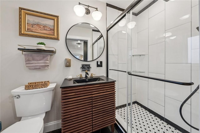 bathroom with toilet, a shower stall, and vanity