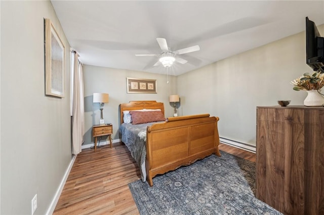 bedroom with baseboards, ceiling fan, baseboard heating, and wood finished floors