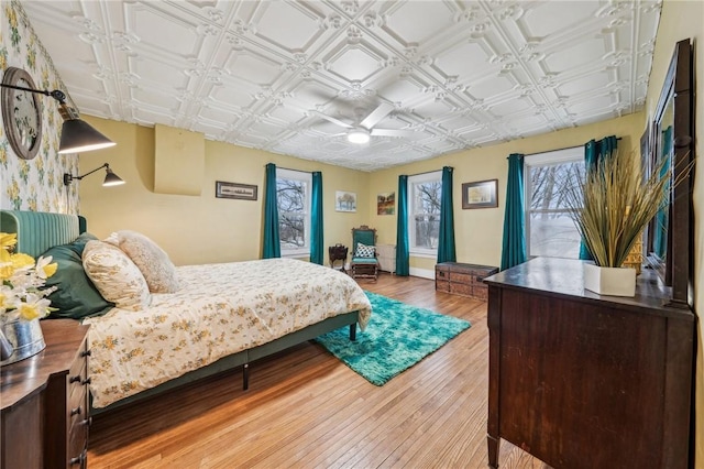 bedroom featuring an ornate ceiling, ceiling fan, and wood finished floors