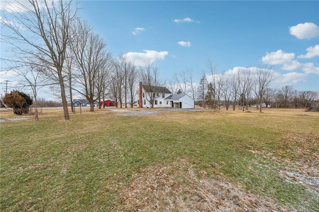 view of yard with a garage and driveway