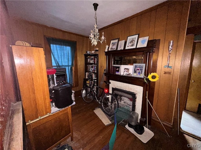 office featuring ornamental molding, a brick fireplace, wooden walls, and wood finished floors