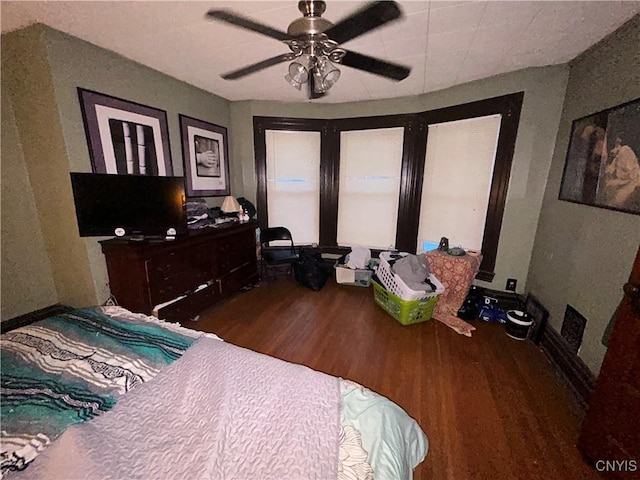 bedroom featuring ceiling fan, baseboards, and wood finished floors