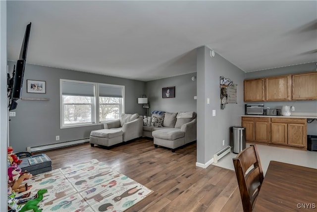 living area with baseboards, a baseboard radiator, a baseboard heating unit, and wood finished floors