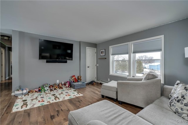 living area featuring a baseboard radiator and wood finished floors