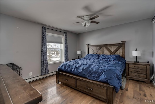 bedroom featuring a baseboard radiator, wood-type flooring, and a ceiling fan