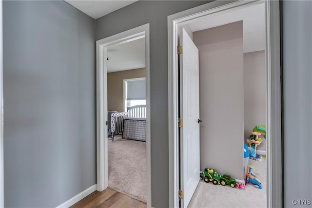 hallway with baseboards and carpet flooring