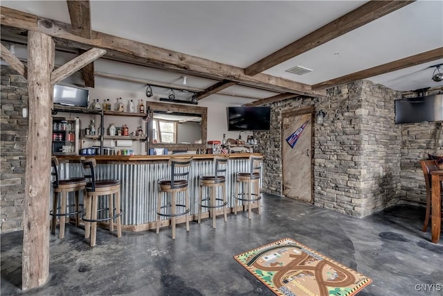 bar with concrete flooring, beam ceiling, visible vents, and a dry bar