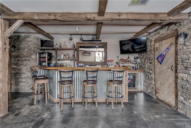 bar featuring visible vents, a bar, concrete floors, and beam ceiling