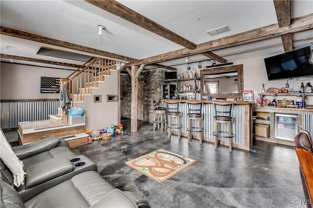 living area with beam ceiling, visible vents, stairway, and a bar