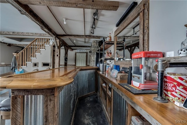 bar featuring a bar, stairway, and rail lighting