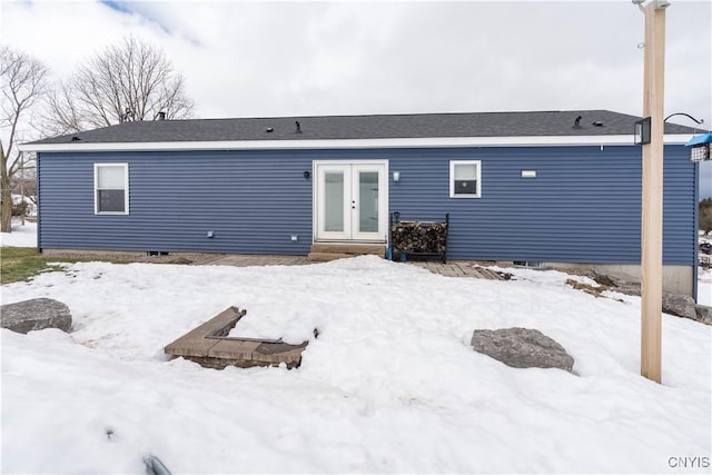 snow covered house with french doors