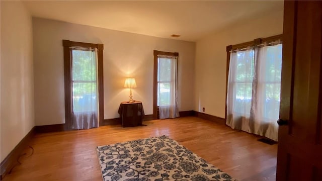 sitting room with plenty of natural light, light wood-style flooring, and baseboards