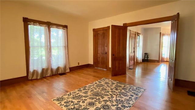 unfurnished room with visible vents, baseboards, and wood finished floors