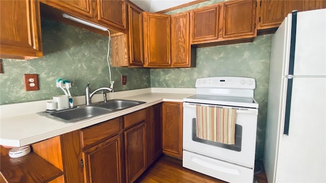 kitchen featuring white appliances, decorative backsplash, light countertops, and a sink